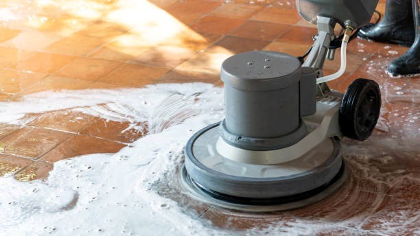 Commercial floor cleaning professional using vacuum on tiles